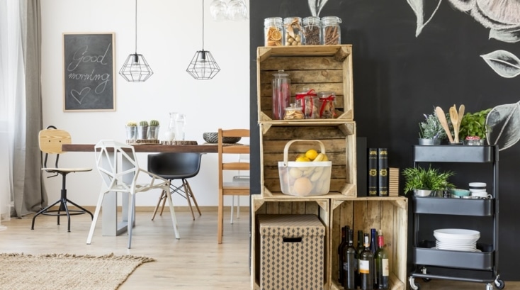 Sistema de almacenamiento sostenible doméstico con cajas de madera reciclada, carrito auxiliar y frascos de vidrio, ideal para mantener el orden con soluciones ecológicas.