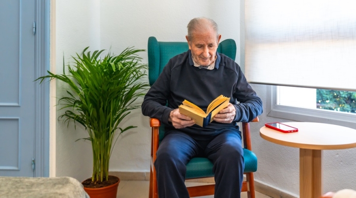 Ejemplo de organización para personas mayores en un ambiente seguro, con silla estable, buena iluminación y zona de lectura sin obstáculos.