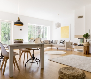 Salón-comedor con organización visual armoniosa, donde el mobiliario en tonos neutros, la simetría de los elementos y la entrada de luz natural crean un ambiente equilibrado y estéticamente ordenado.