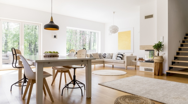 Salón-comedor con organización visual armoniosa, donde el mobiliario en tonos neutros, la simetría de los elementos y la entrada de luz natural crean un ambiente equilibrado y estéticamente ordenado.