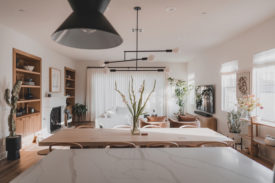 Zona abierta de cocina y salón con diseño minimalista y organización visual basada en líneas limpias, materiales naturales y distribución equilibrada.